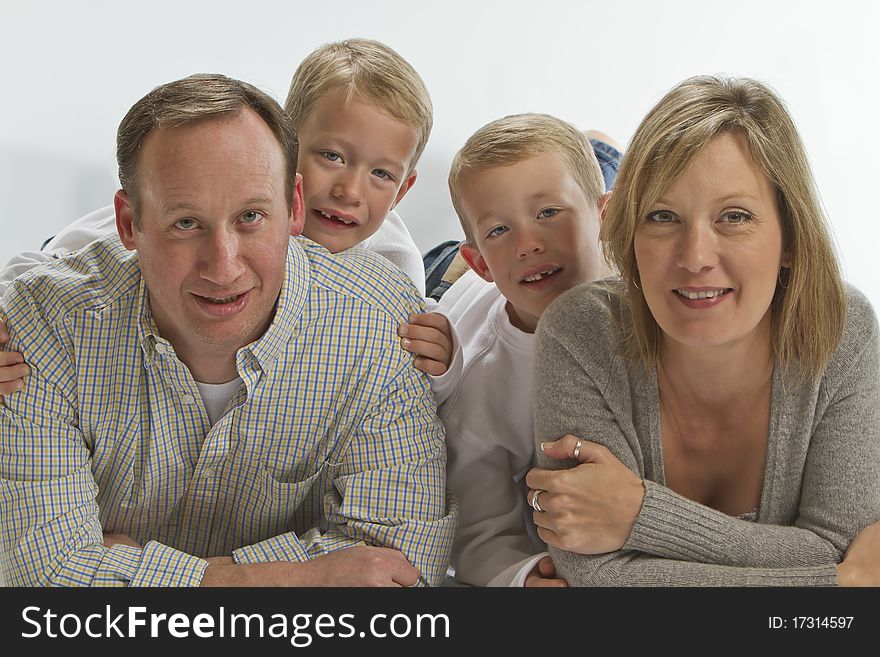 Happy parents with 6 years old identical twins looking ahead smiling