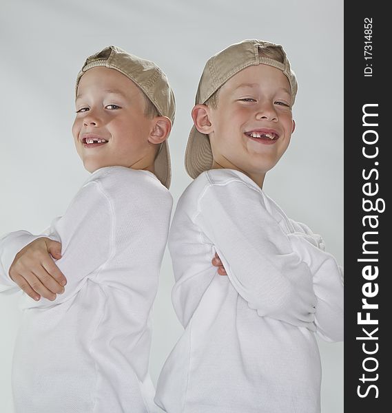 6 years old identical twins wearina a baseball hats smiling