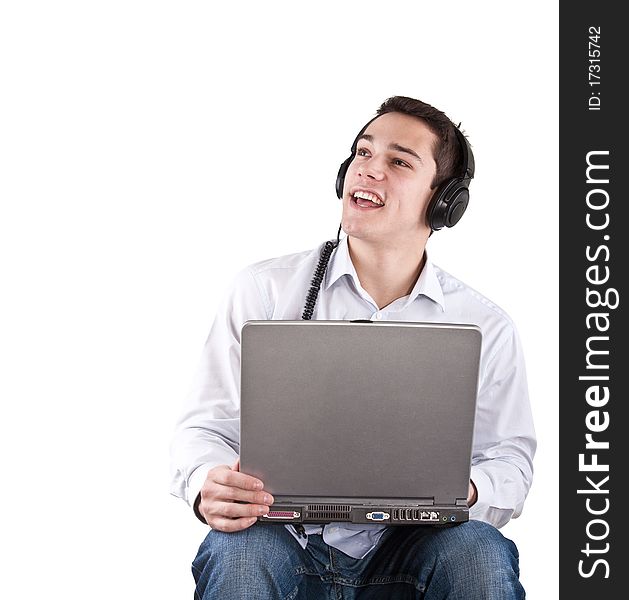 Young man sitting relaxing and listening to music from his laptop. Young man sitting relaxing and listening to music from his laptop.