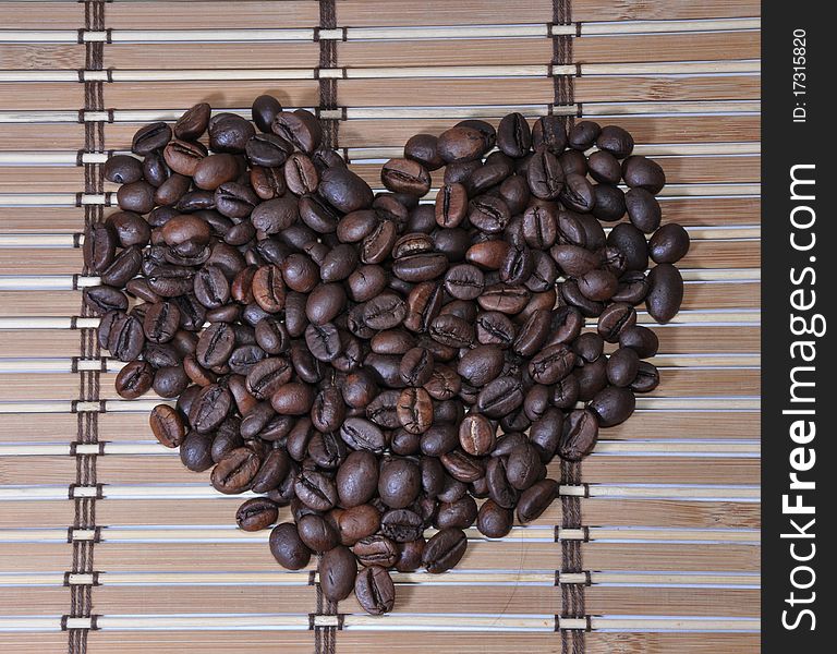 Picture of grains of lying black coffee as a heart. Picture of grains of lying black coffee as a heart