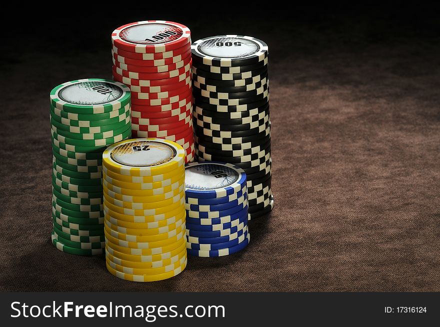 Multi-colored poker chips on a brown table. Multi-colored poker chips on a brown table