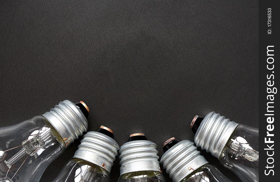 Closeup of few light bulbs on dark metal background