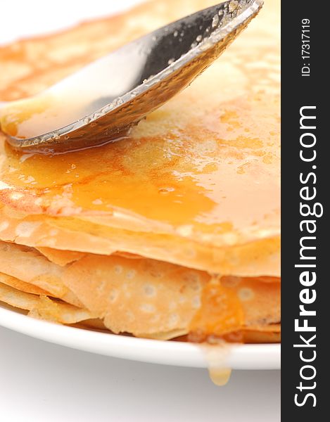 Pancakes with honey on a white plate