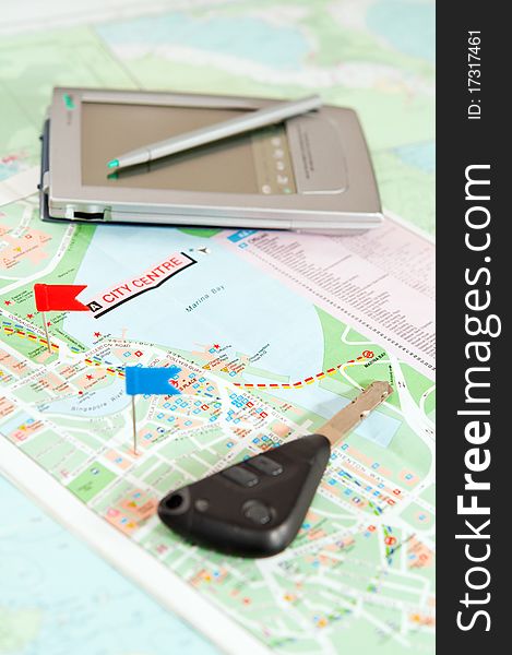 Road map with a red and blue flag, car keys, electronic organizer. closeup. Road map with a red and blue flag, car keys, electronic organizer. closeup.