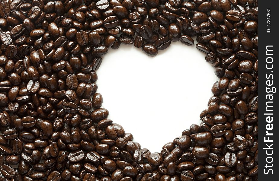 Coffee beans with space in heart shape on white background