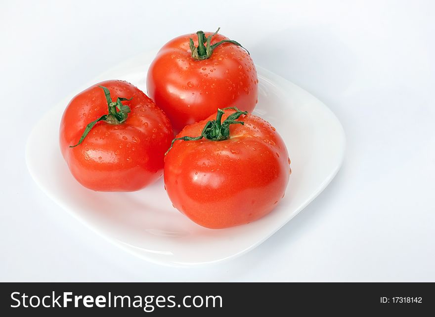 Juicy bright tomatoes on white plate. Juicy bright tomatoes on white plate