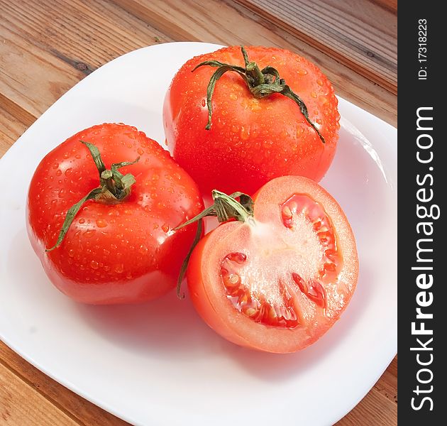 Juicy bright tomatoes on white plate. Juicy bright tomatoes on white plate