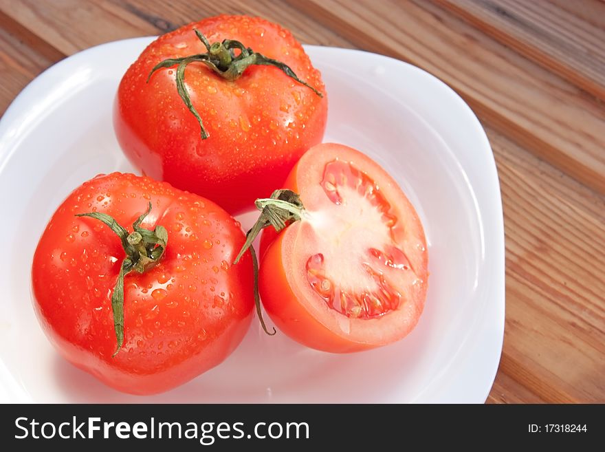 Juicy bright tomatoes on white plate. Juicy bright tomatoes on white plate