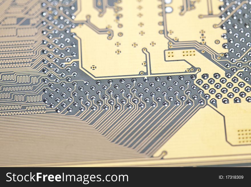 A close up shot of the backside of a computer circuit board, also known as a motherboard