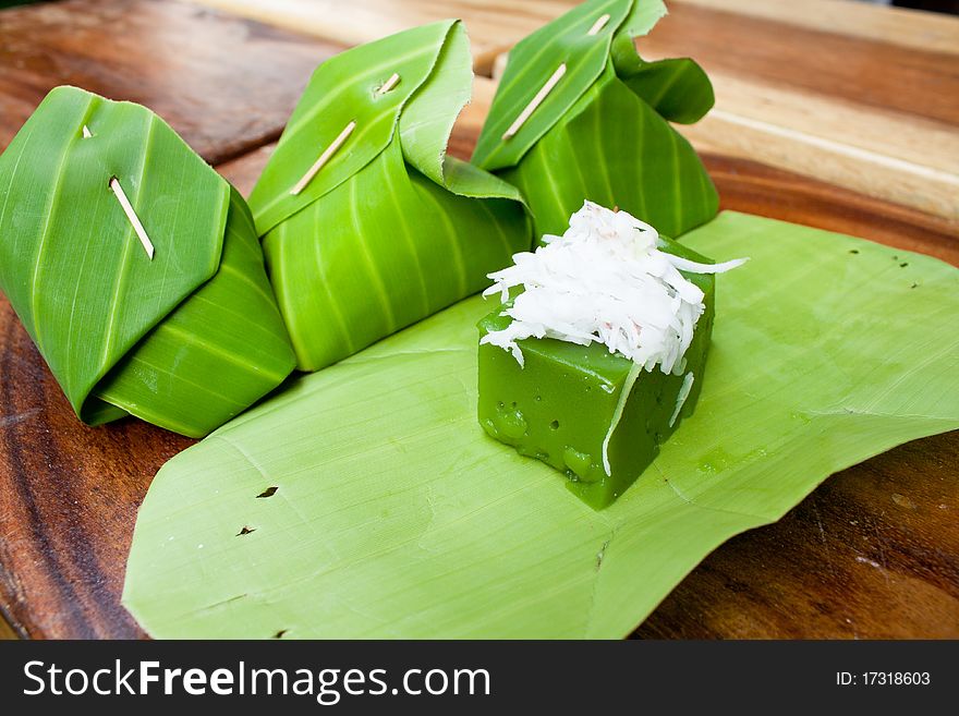 Tradition thai dessert, Green sweet pudding call Kanom Peakpoon made of Pandanus leaf flavor and coconut and banana leaf as it's packages