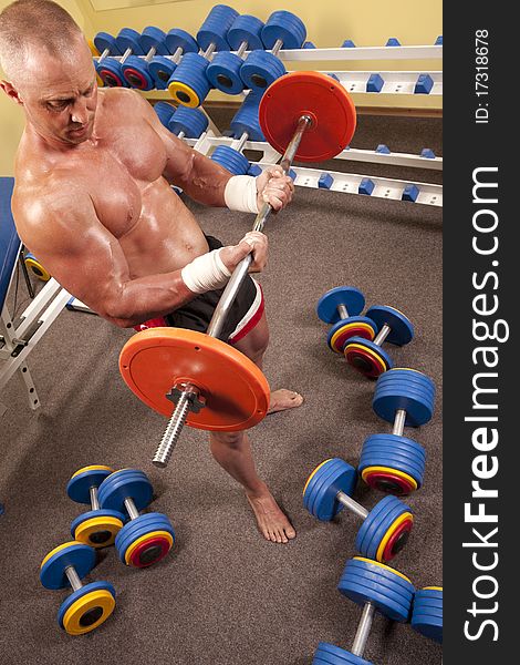 Muscular man with a bar weights in hands training
