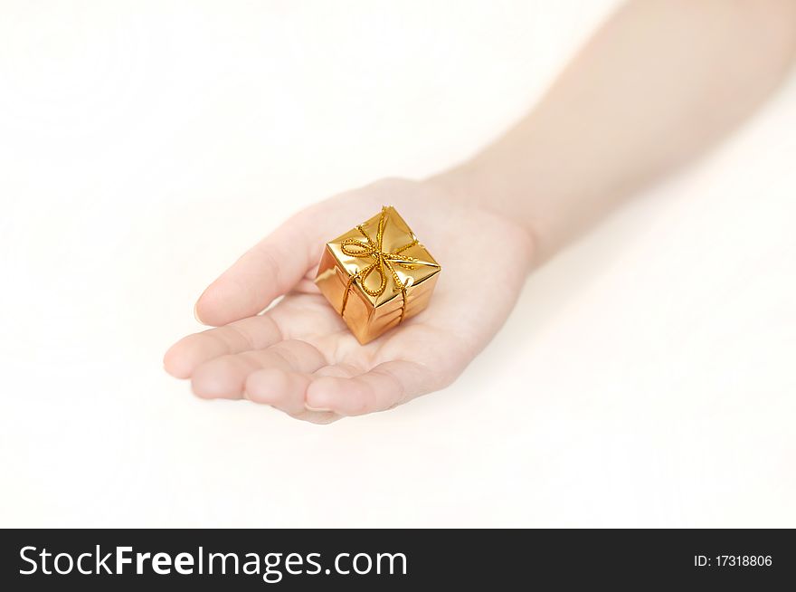 Woman's hand with a small yellow gift. Woman's hand with a small yellow gift