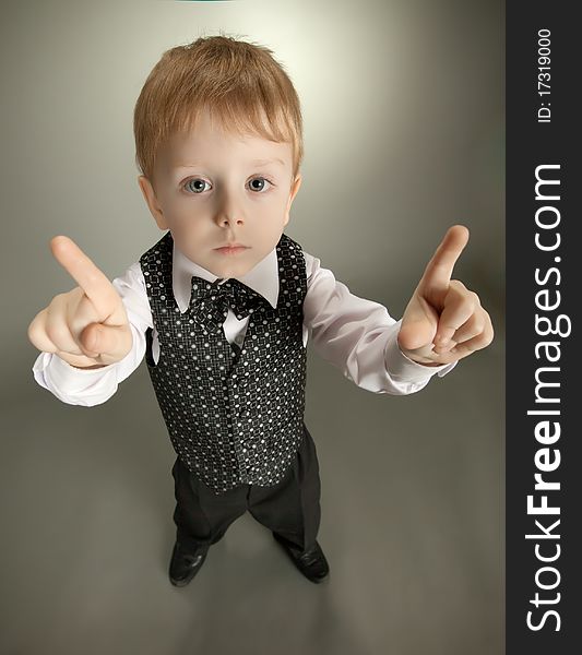 The little boy in a suit of the businessman shows gestures by hands