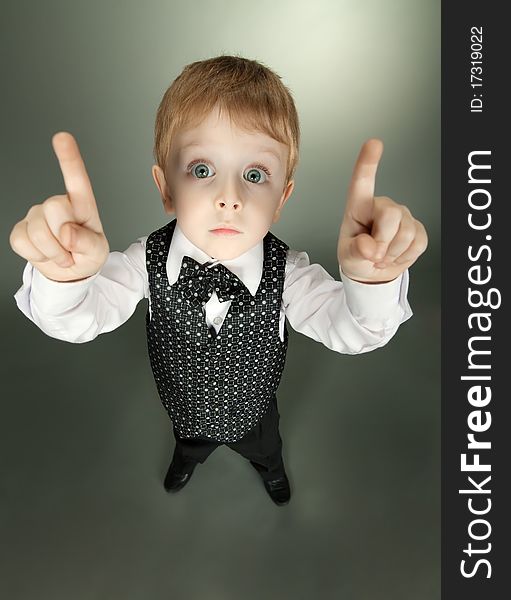 The little boy in a suit of the businessman shows gestures by hands
