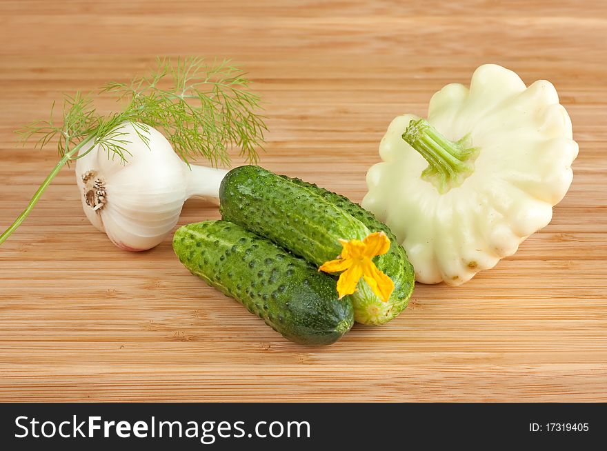 Cucumbers, squash and garlic on cutting board