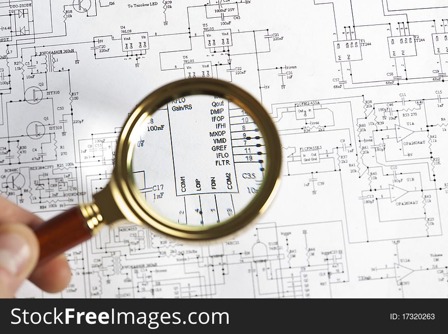 The approximation using a magnifying glass on the electronic schematic diagram.Ideal technology background.