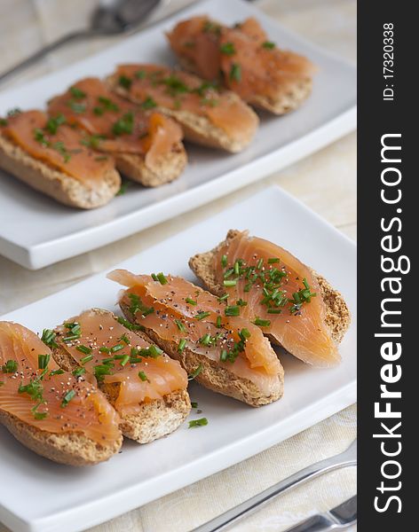 Swedish crisp bread topped with smoked salmon and chives. Swedish crisp bread topped with smoked salmon and chives