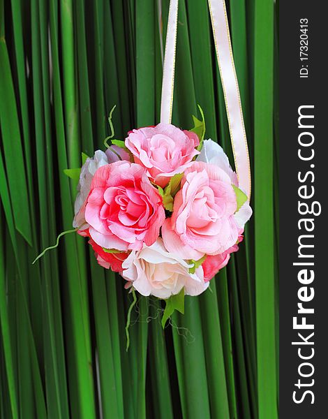 Pink rose bouquet on green background in wedding party