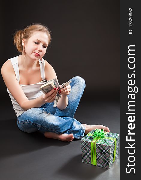 Beautiful girl with a gift against a dark background. Beautiful girl with a gift against a dark background