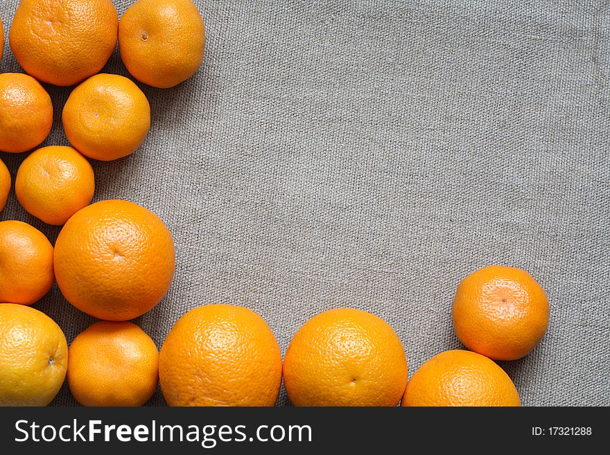 Set of oranges and tangerines lying on canvas background with copy space. Set of oranges and tangerines lying on canvas background with copy space