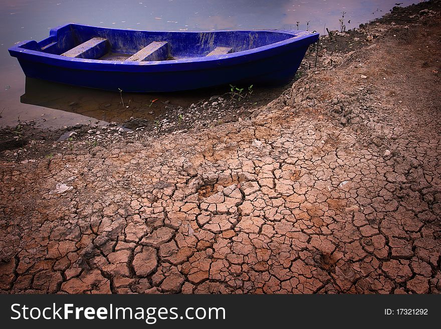 Plastic boat on dry soil in drought season