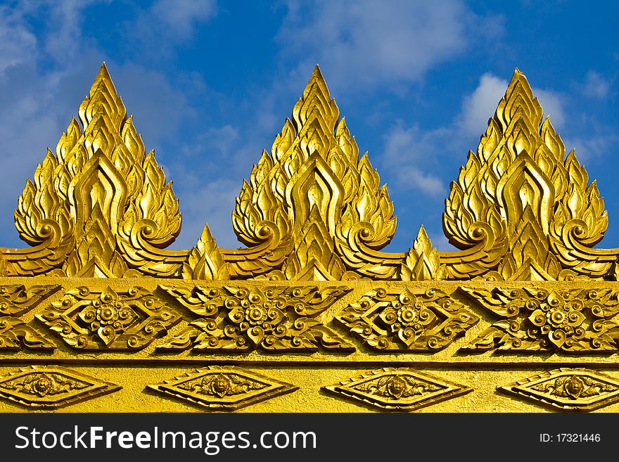 Golden cement sculpture of Thai art on the top of the temple's wall in Thailand. Golden cement sculpture of Thai art on the top of the temple's wall in Thailand