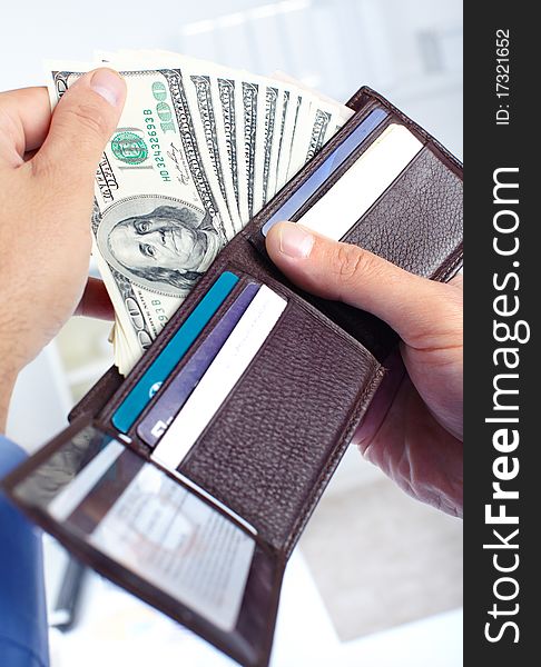 Male hands holding a wallet and money us dollars.