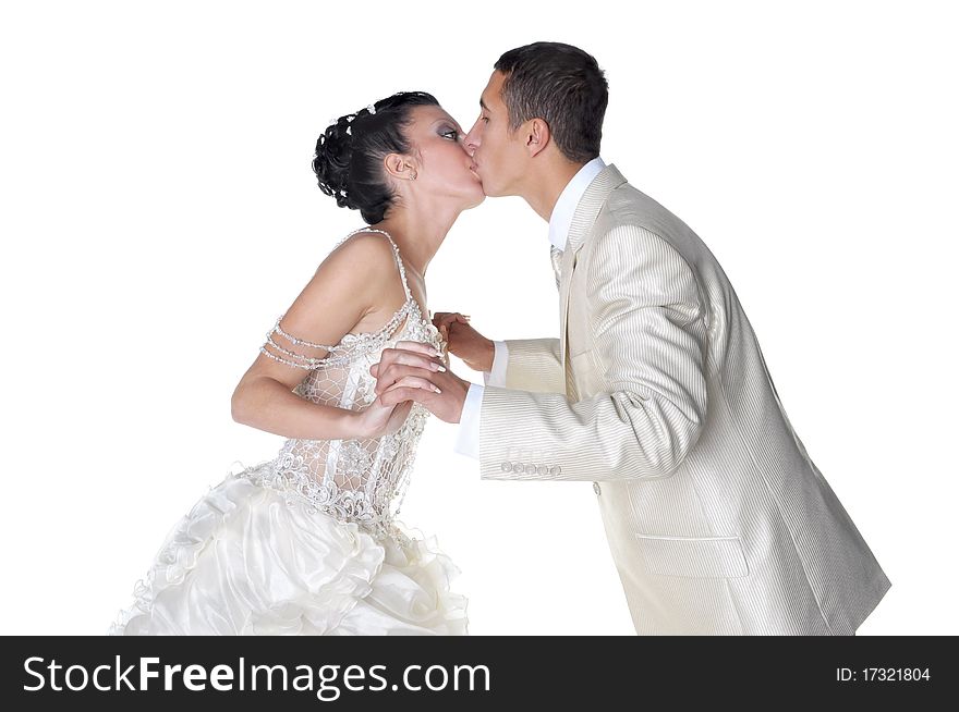 Isolated on white groom is kissing his bride wearing in wedding dress. Isolated on white groom is kissing his bride wearing in wedding dress