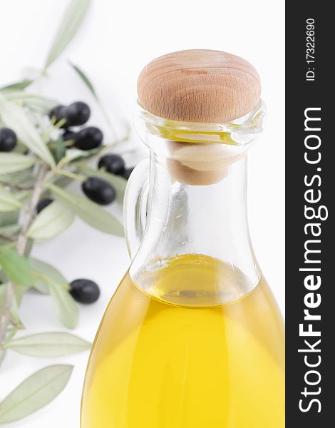 A bottle of virgin olive oil with a branch of olive tree