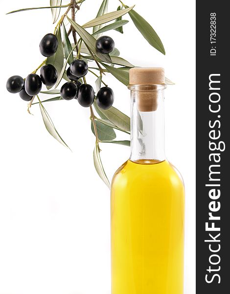 A bottle of virgin olive oil with a branch of olive tree