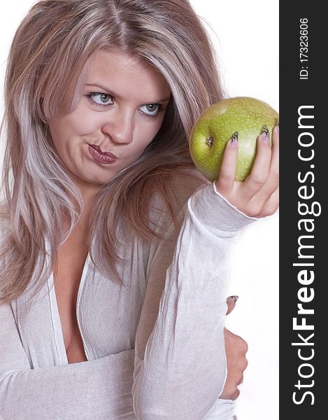 The lovely girl holds a green apple on a white background. The lovely girl holds a green apple on a white background