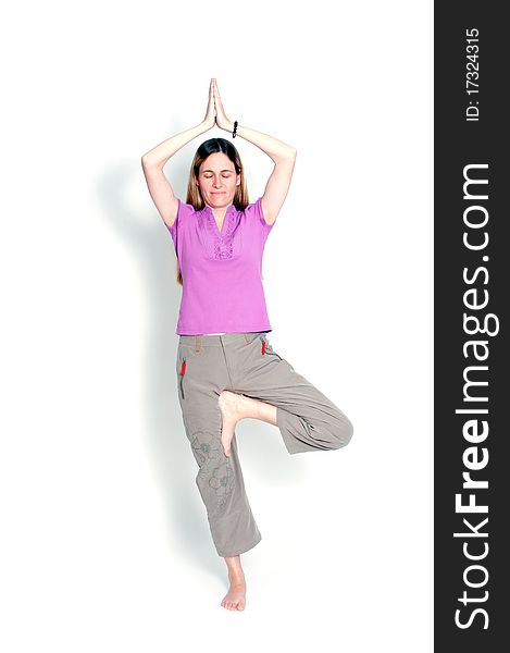 Young woman practicing yoga in the tree posture with closed eyes