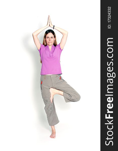 Young woman practicing yoga in the tree posture