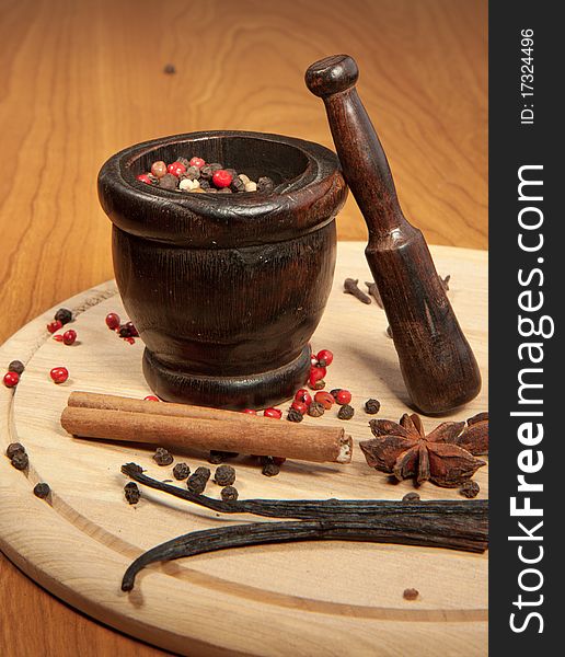 Mix of the spices on the wooden desk with wooden mortar