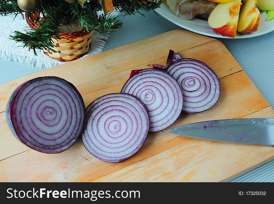 Some pieces of onion with knife on the wooden board