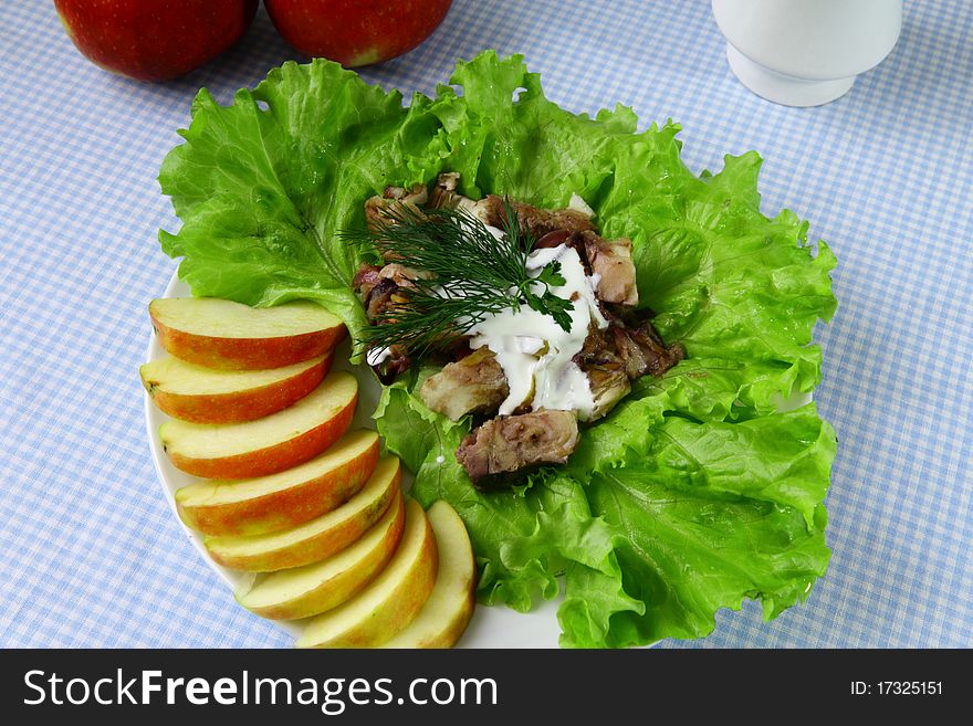 Fish with pieces of apple and lettuce on the plate. Fish with pieces of apple and lettuce on the plate