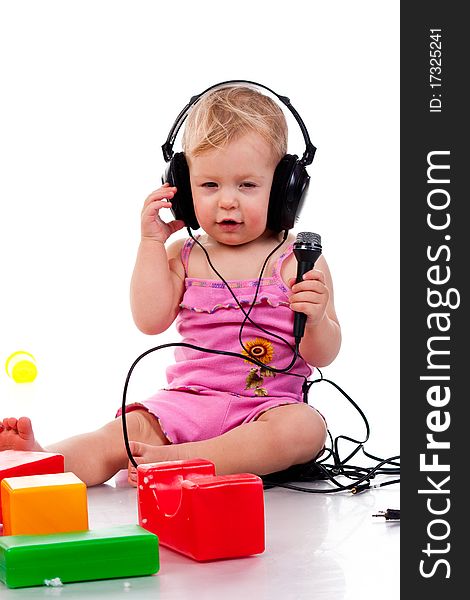 Baby with headphones and microphone, isolated on a white background