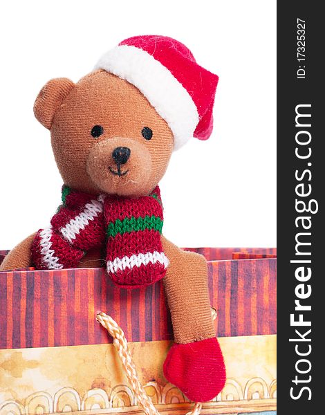 Teddy bear with santa`s hat sitting in a gift box isolated on the white