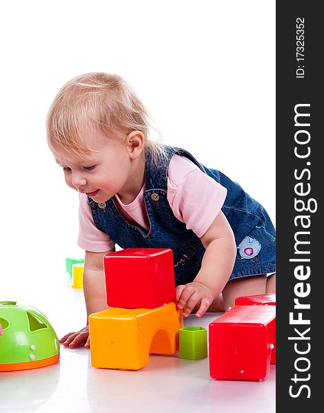 Beautiful baby building a castle with cubes isolated on white