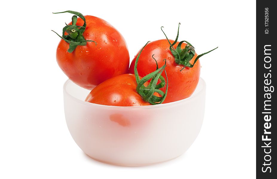 Three juicy tomatoes in the plate isolated on the white