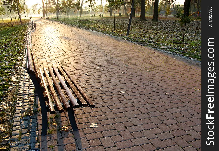 A photo of a wooden bench in park in autumn.