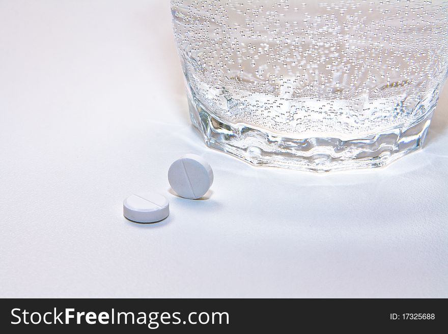 Two pills and a glass of water. Two pills and a glass of water