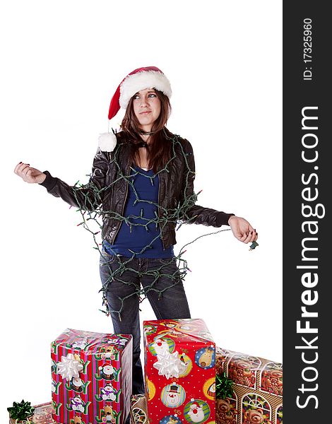 A woman is standing by a stack of presents with lights tangled on her body. A woman is standing by a stack of presents with lights tangled on her body.