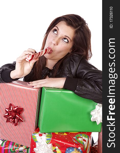 A woman is leaning on a stack of presents licking a peppermint stick. A woman is leaning on a stack of presents licking a peppermint stick.