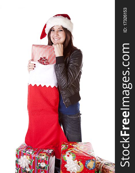 A woman is standing by a big stocking with presents. A woman is standing by a big stocking with presents