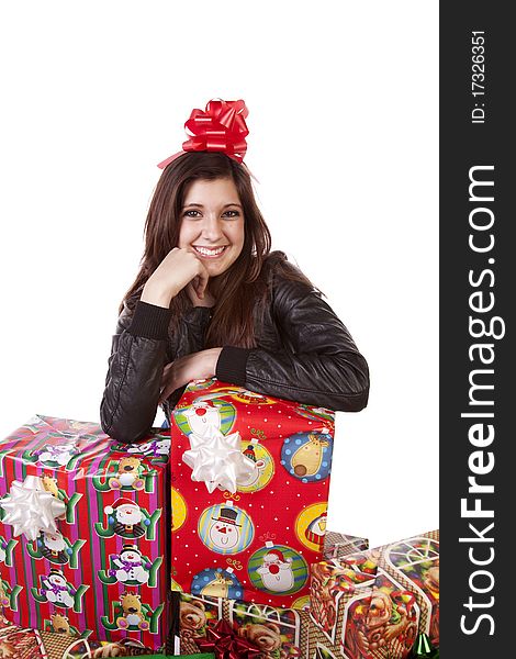 A Woman is by a stack of presents with a bow in her hair. A Woman is by a stack of presents with a bow in her hair.