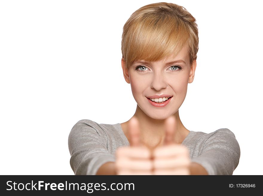 Portrait of an excited young woman gesturing a thumbs up sign against white background. Portrait of an excited young woman gesturing a thumbs up sign against white background