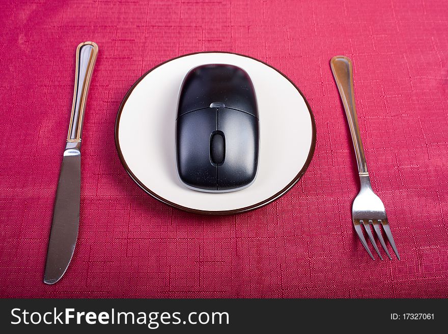 Concept: fork, plate with mouse and knife on a table. Concept: fork, plate with mouse and knife on a table