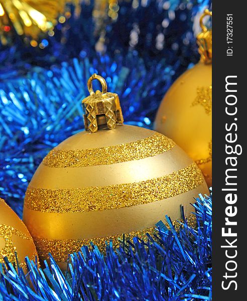 Golden Christmas bauble in blue tinsel. Golden Christmas bauble in blue tinsel