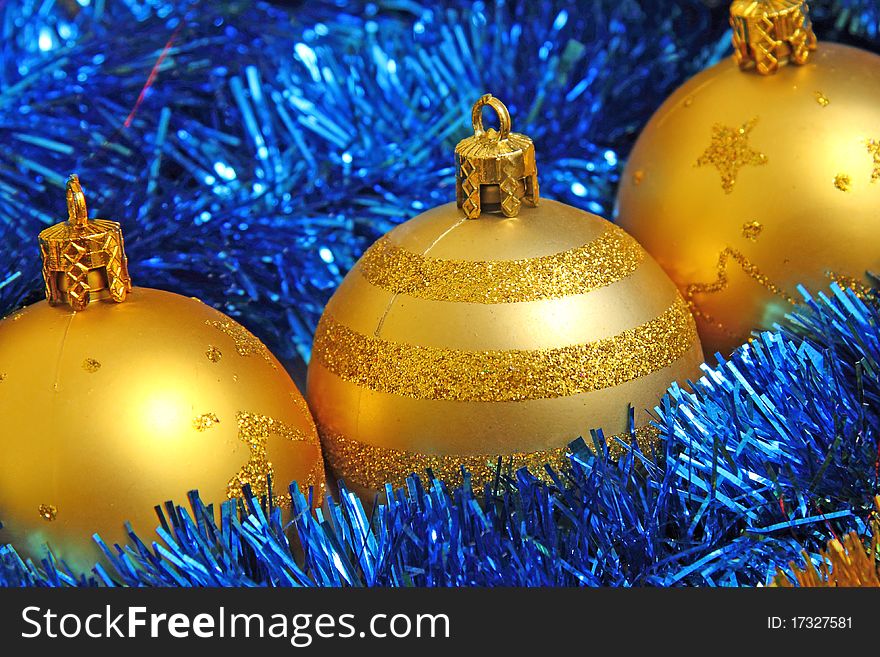 Golden Christmas baubles in blue tinsel. Golden Christmas baubles in blue tinsel